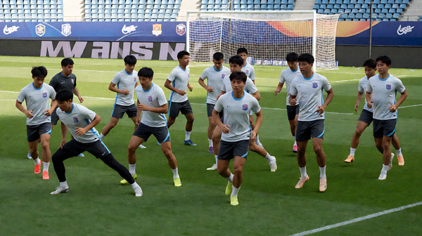 足球赛前球队在球场上进行热身训练的场景